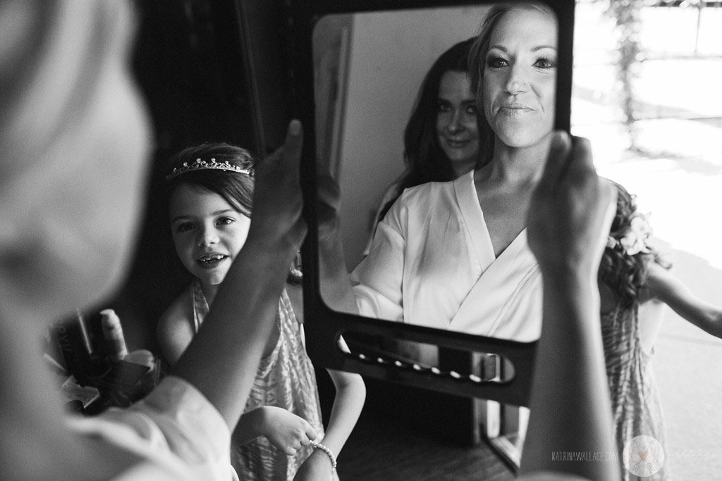 The beautiful bride sees her hair and makeup before putting on her wedding gown.