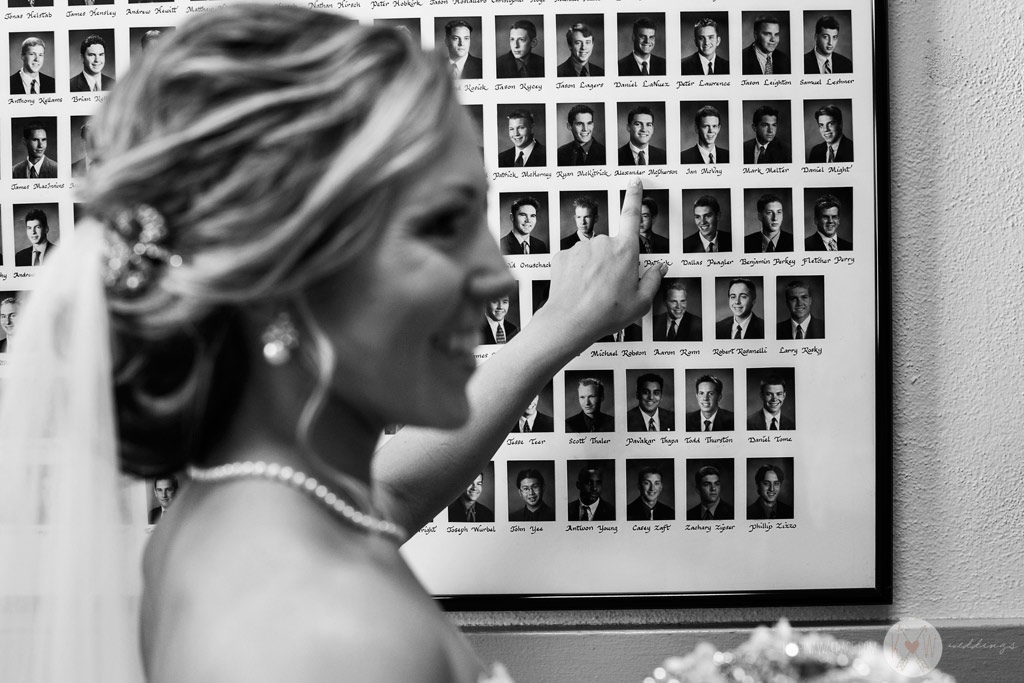 The bride points out her groom's portrait on the wall at Brophey Chapel just before the ceremony