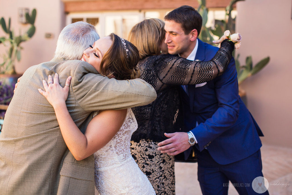 Bride and groom hug family members