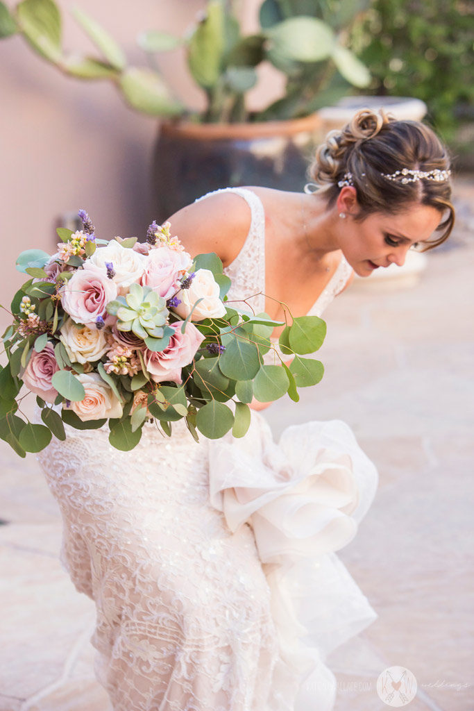 The bride straightens her gown