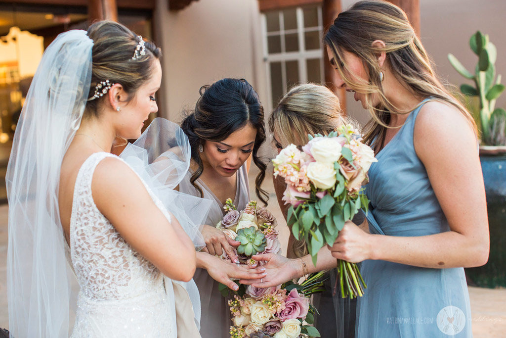 The bridesmaids hug the bride in celebration after the ceremony.