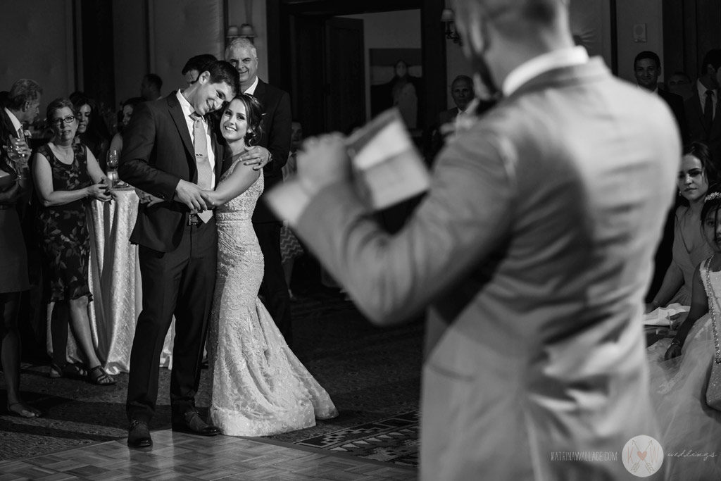 The groom removes the garter and prepares to throw it.