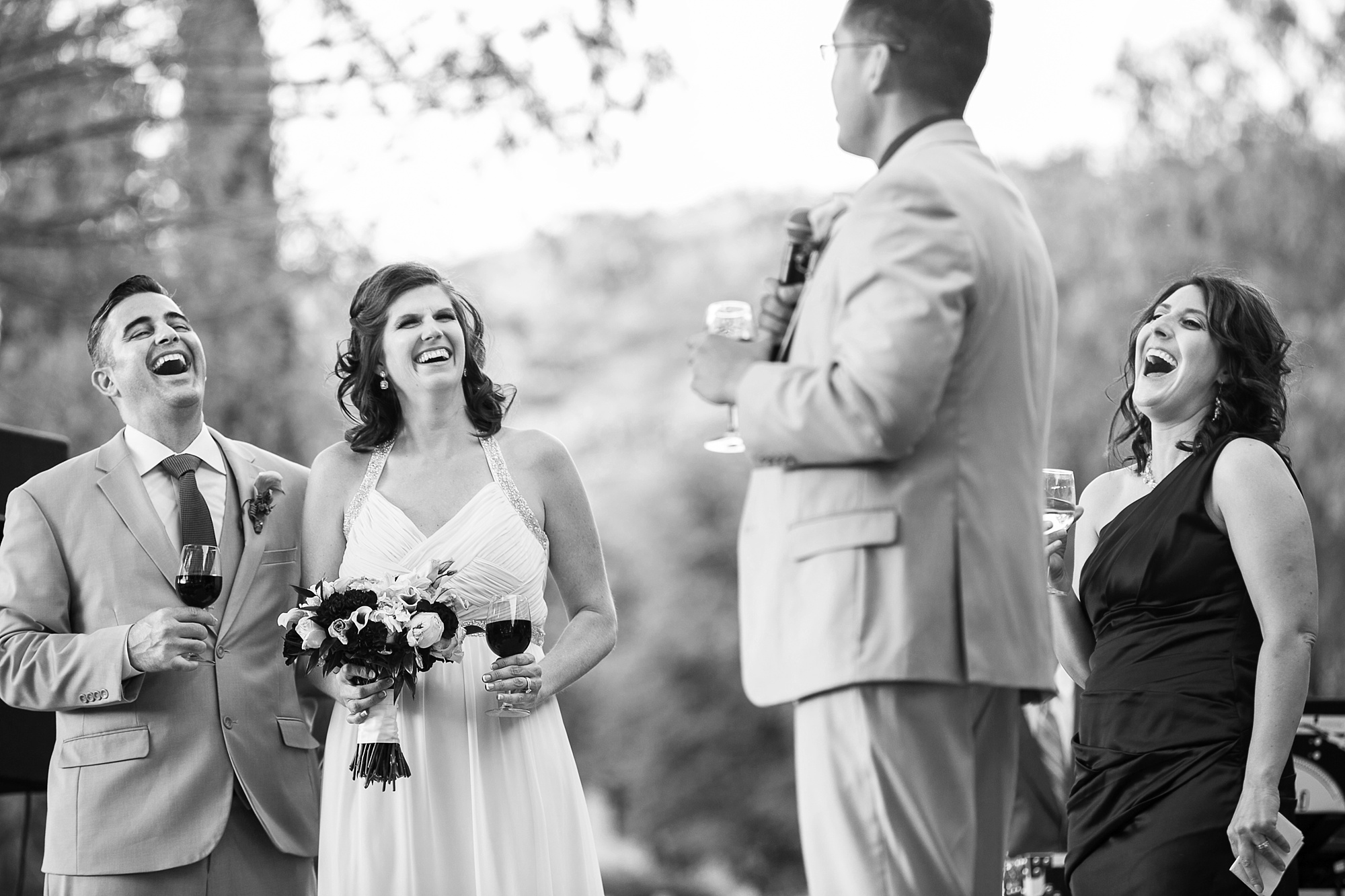 Newlyweds laugh during a toast at their Dancing Apache Lodge wedding reception